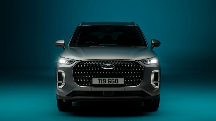 Grey Chery Tiggo 9 Front View Headlights On Blue Backdrop