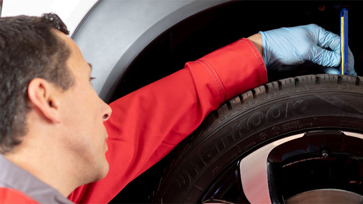 technician checking tyre tread