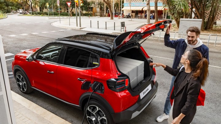 Man and Woman Closing Boot of a Red Citroen e-C3 Van While it Charges On Roadside