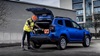 Working professional loading the cargo area of a Blue Dacia Duster Commercial