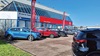 Exterior shot of an MG dealership in Grantham, with cars parked out front the main entrance, and the MG flag flying above