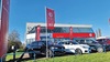 Exterior shot of an MG dealership in Grantham, with cars parked out front, and the MG flag flying above