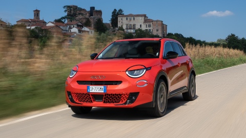 Exterior Front of Red Fiat 600e Driving in Countryside
