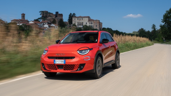 Exterior Front of Red Fiat 600e Driving in Countryside