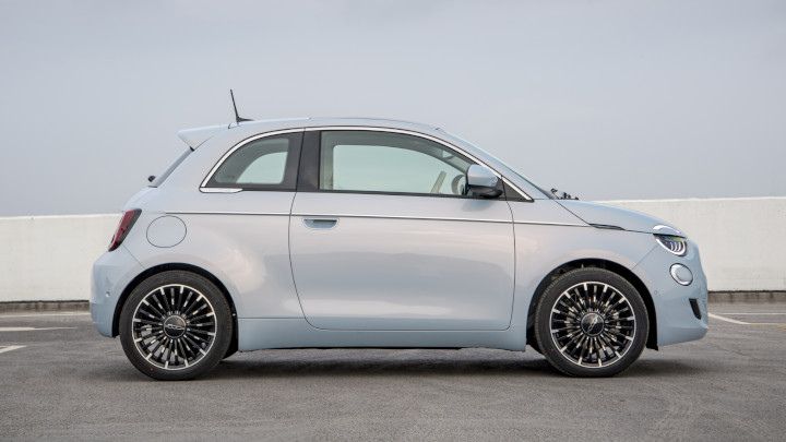 Pale blue Fiat 500 parked in front of a blue wall