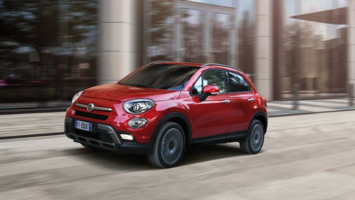 Red Fiat 500 driving in a city