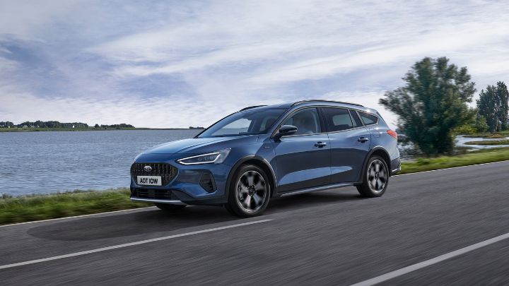 Blue Ford Focus driving by a lake