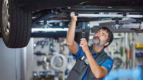 Ford technician completing a video health check report on the underside of a car