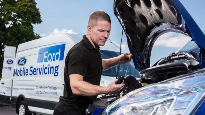 Man checking under the bonnet of a car. Ford Mobile Servicing van is in the background.