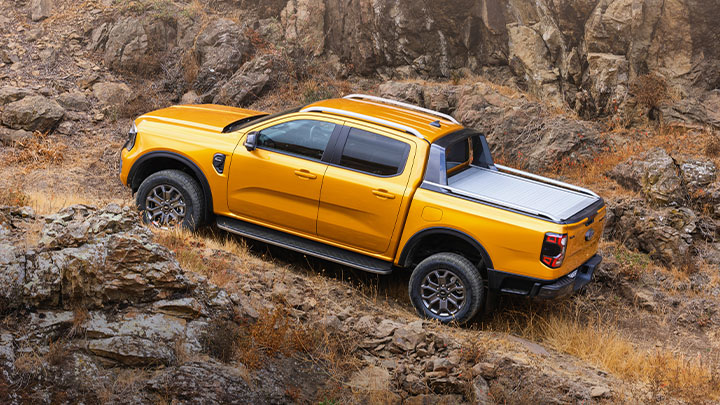 Orange Ford Ranger side profile shot, climbing mountain pass