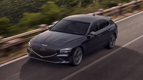 Grey Genesis G70 Shooting Brake driving down a road at sunset