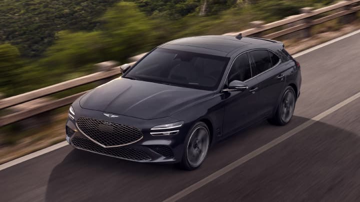 Grey Genesis G70 Shooting Brake driving down a road at sunset