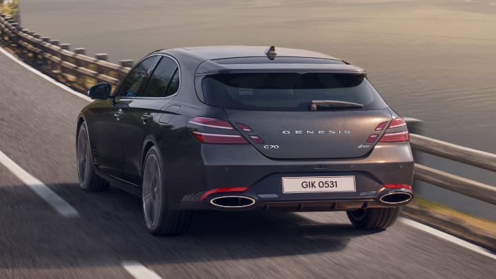 Grey Genesis G70 Shooting Brake driving away from the camera on a bridge