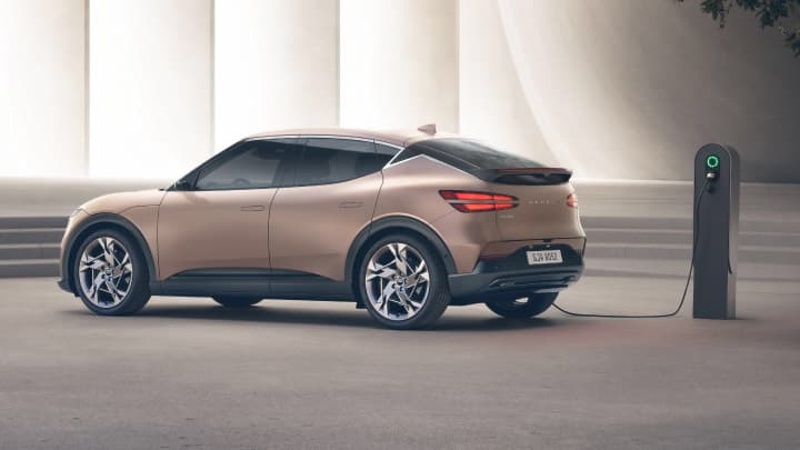 Beige Genesis GV60 in a studio being charged