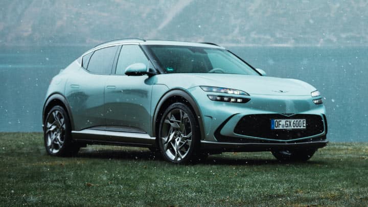 Blue Genesis GV60 parked with lake in the background