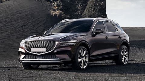 Grey Genesis GV70, parked on black sands of a mountain