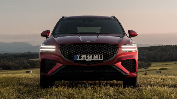 Red Genesis GV70 front shot whilst parked in a field
