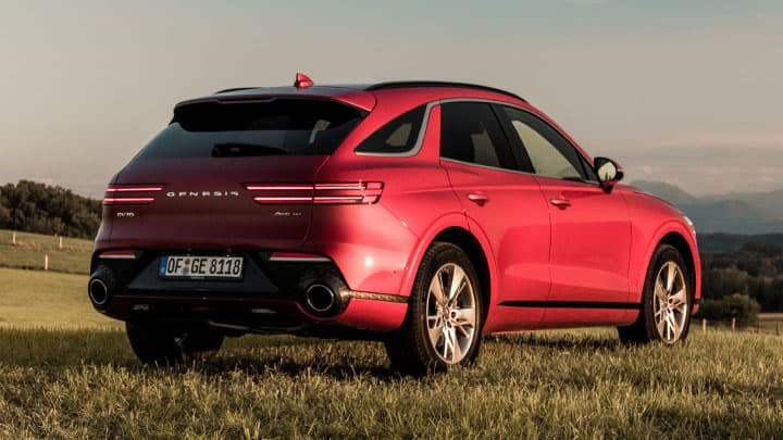 Red Genesis GV70 parked in a field
