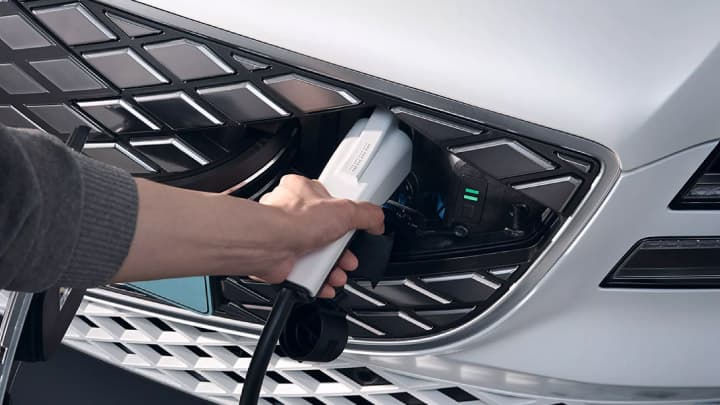 Close up of a white Genesis GV80 being placed on charge