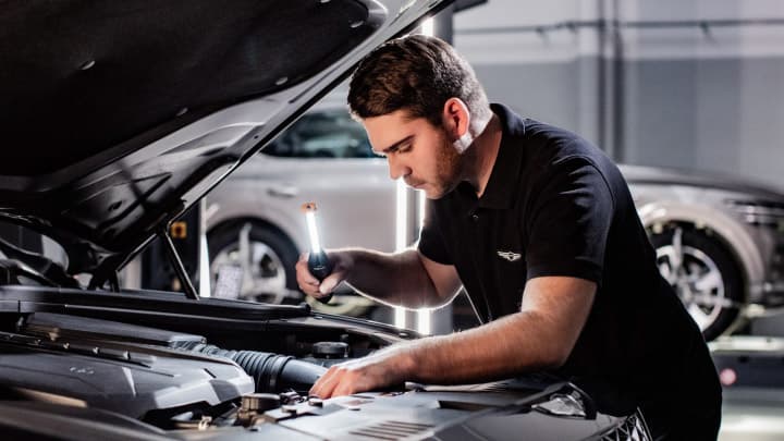 Genesis technician servicing a car in a workshop