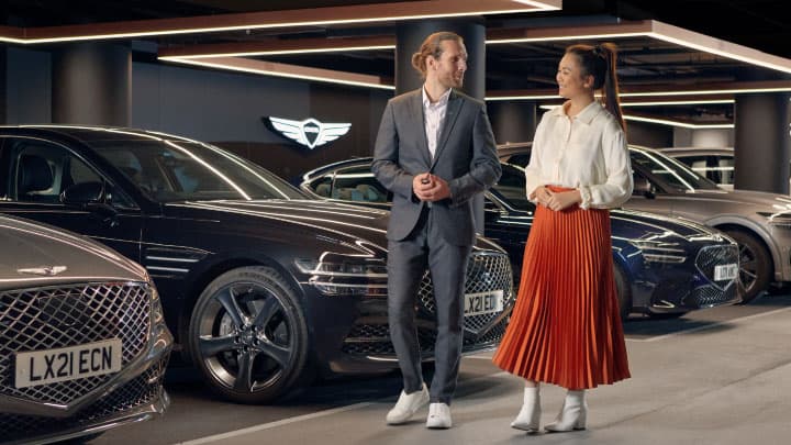 A customer being toured around a Genesis showroom by one of the staff