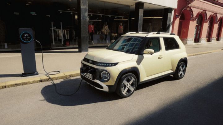 Beige Hyundai Insper being charged on the road