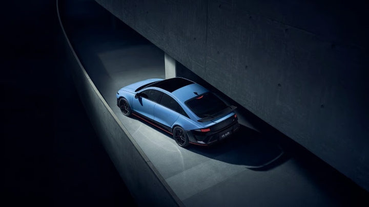 Aerial side view of the Hyundai IONIQ 6 N driving through a covered architectural space