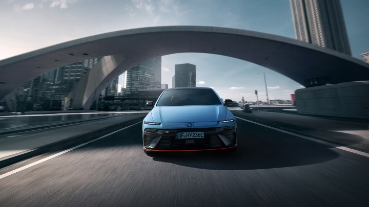 Hyundai IONIQ 6 N driving head‑on through an urban environment