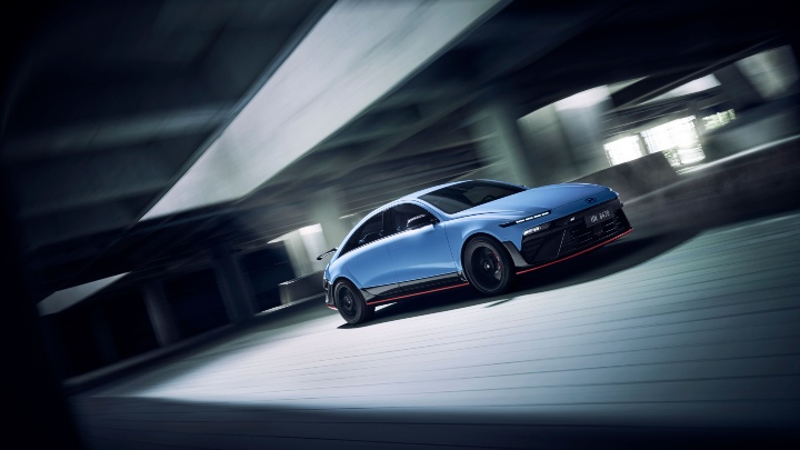 Hyundai IONIQ 6 N driving from a side angle in a dramatic concrete setting