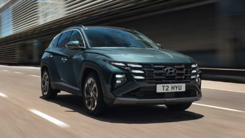 Green Hyundai TUCSON Hybrid Driving On Road