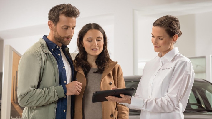 Assistant Showing Couple Tablet in Hyundai Dealership