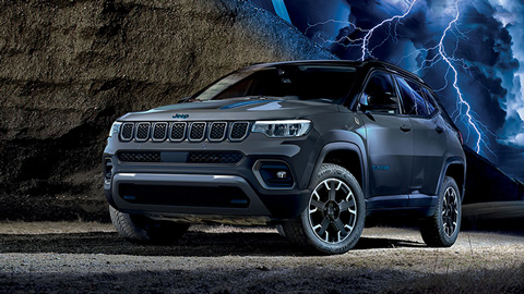 A hybrid studio shot of a grey Jeep Compass with a rock and thunder background