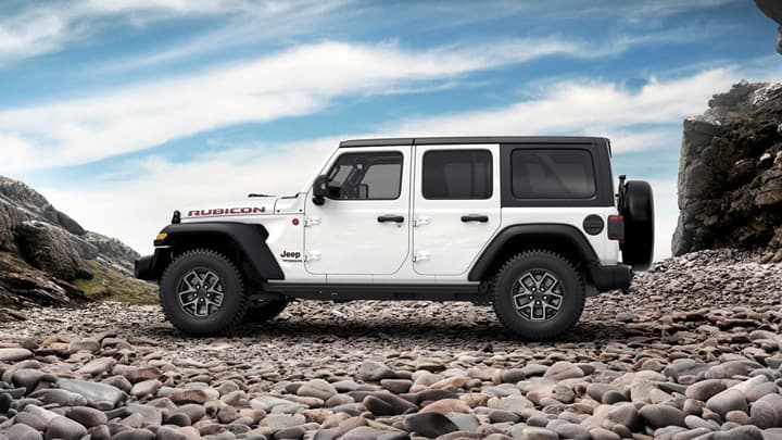 Side shot of a white Jeep Wrangler parked on some cobbles