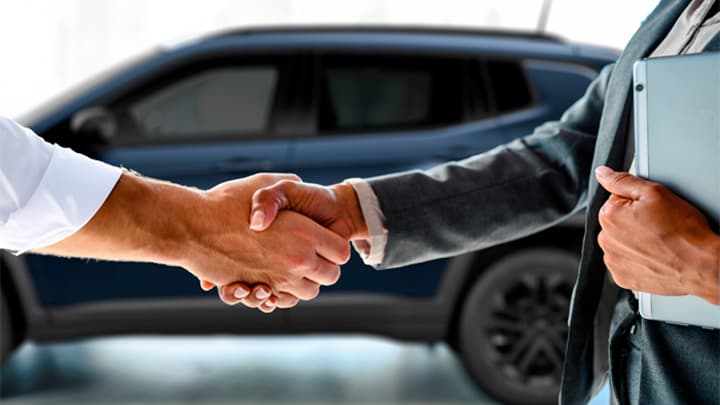 Close up of two men shaking hands, completing a car sale