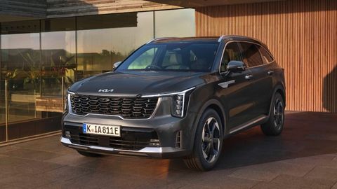 Kia Sorento parked in front of a wooden garage door