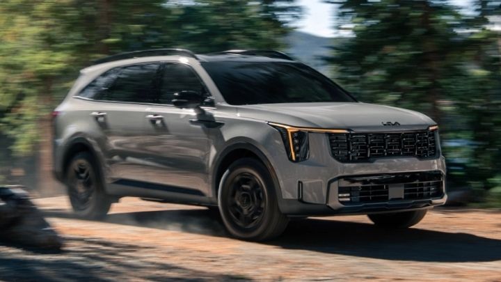 Silver Kia Sorento driving off-track in the woods