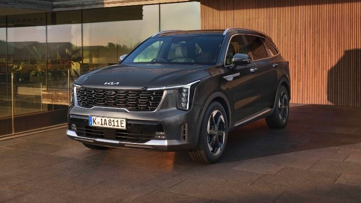 Grey Kia Sorento parked in front of a modern looking house