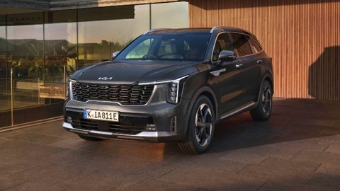 Grey Kia Sorento parked in front of a modern looking house