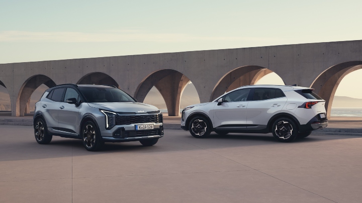 Duo of Silver Kia Sportage Models Static Next to Bridge