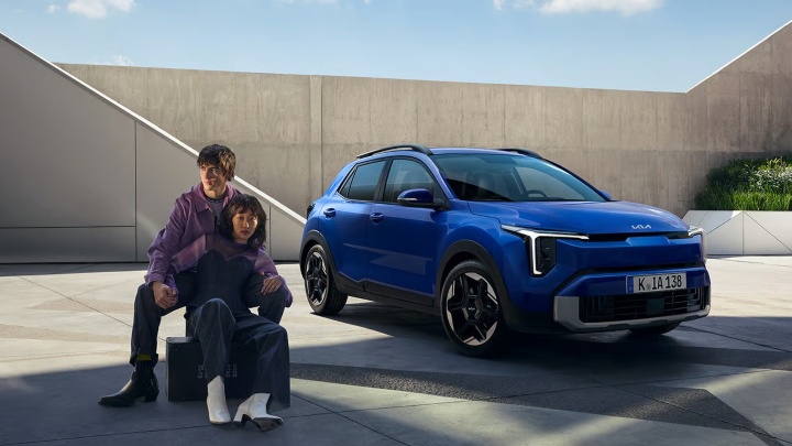 Blue Kia Stonic compact SUV parked outdoors in a modern architectural setting
