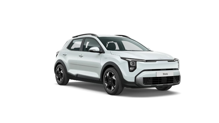 White Kia Stonic compact SUV shown from a front three‑quarter angle in a contemporary setting