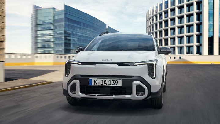 White Kia Stonic compact SUV shown from a front three‑quarter angle in a contemporary setting