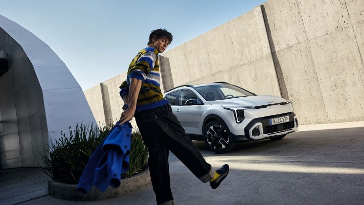 White Kia Stonic compact SUV parked in a modern outdoor architectural space