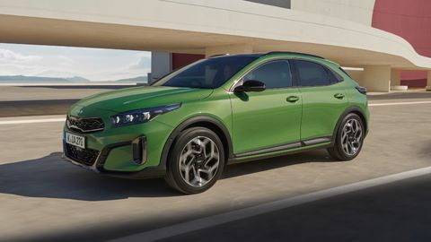 Green Kia Xceed driving in a modern city