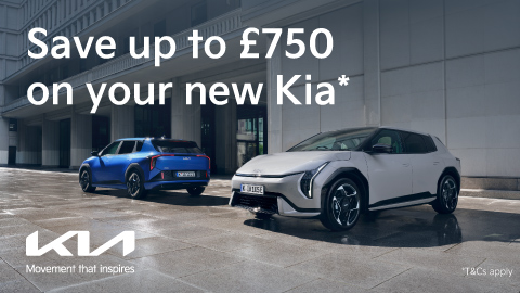 One White and One Blue Kia Parked Outside Modern Building With Promotional Messaging