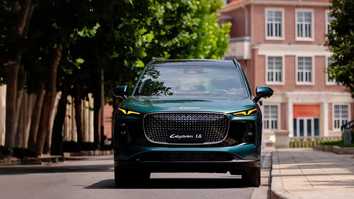 Green LEPAS L8 Driving Front-On in Urban Area