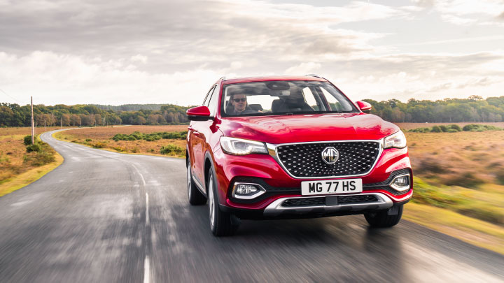 Red MG HS Driving On Road Front On