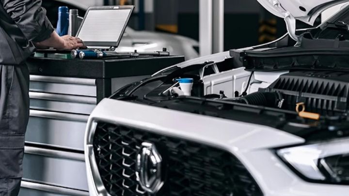 White MG with the bonnet open being serviced