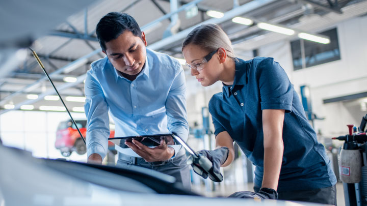 Man and Woman Fixing a Car