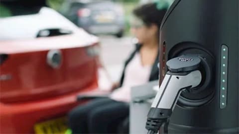 Close up of a car charger, which is plugged into a red Vauxhall Corsa